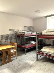 a room with three bunk beds and a table at Apartament 01 in Poznań