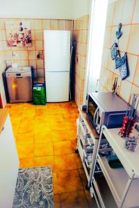 a kitchen with a white refrigerator and a wooden floor at Casadamarepg Gallipoli in Pizzo +17 photos
