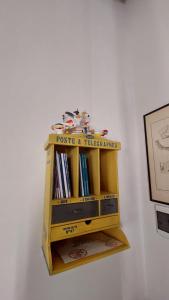 a wooden book shelf on a wall with books at Casa di LU in Matera