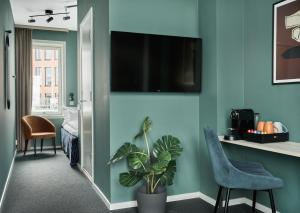 a room with a tv on a wall with a plant at Smarthotel Oslo in Oslo