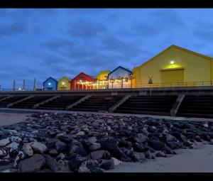 a row of colorful houses on a beach at night at Sharons Lyons lido Caravan 3 bedrooms in Prestatyn