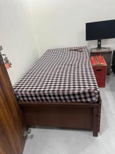 a bed with a black and white checkered mattress at Singhal PG-Rooms in New Delhi +6 photos