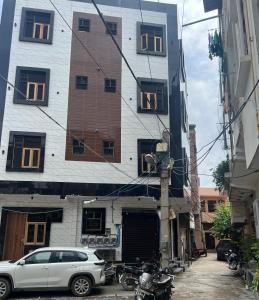 a white car parked in front of a building at Singhal PG-Rooms in New Delhi
