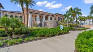 un edificio con palmeras y acera en Amazing Villas 20 minutes away from Disney!, en Kissimmee