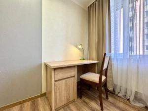 a desk with a chair next to a window at ApartPoltava Cучасні 2-кімн апартаменти з великою кутовою ванною ЦЕНТР МІСТА in Poltava