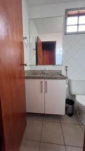 a bathroom with a sink and a toilet and a mirror at Chalé Lazer Gravatá com 3 suítes - na Suíça Brasileira in Gravatá