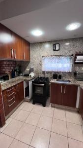 a kitchen with wooden cabinets and a stove top oven at Chalé Lazer Gravatá com 3 suítes - na Suíça Brasileira in Gravatá