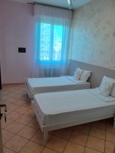 two beds in a room with a window at Locanda San Martino in Collecchio