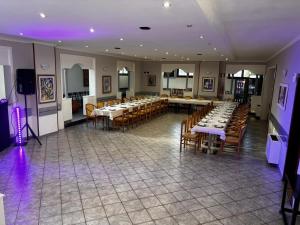 a banquet hall with tables and chairs and purple lights at Locanda San Martino in Collecchio