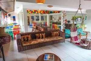 a living room with a couch and a hammock at Pousada Flor de Maraca in Porto De Galinhas