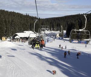 a group of people on a ski lift in the snow at Holiday Home Cokla in Zreče