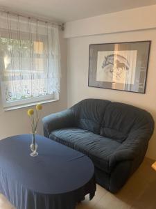 un soggiorno con un divano blu e un tavolo di fewoholz a Heppenheim