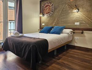 a bedroom with a large bed with blue pillows at El Indio Chocolatería Boutique in Pinto