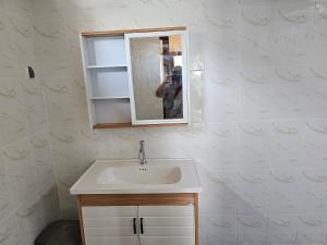 una persona tomando una foto de un lavabo del baño en Bluecoral Bungalows, en Gili Meno