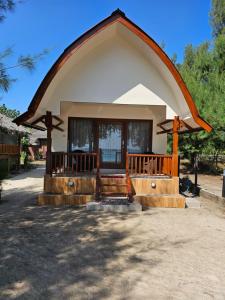 una pequeña casa con un techo grande en Bluecoral Bungalows, en Gili Meno