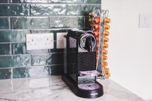 Una plancha negra sobre un mostrador junto a una pared en Luxury 2 Bed in Reading - Free Parking & Fast Wi-Fi, en Reading