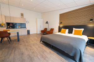 a bedroom with a bed and a desk and a kitchen at De Berkenhof Aparthotel in Nes
