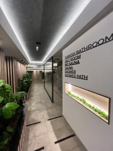 a hallway with plants and a sign on the wall at Apartman Njegoš Lux Titova vila in Palisad