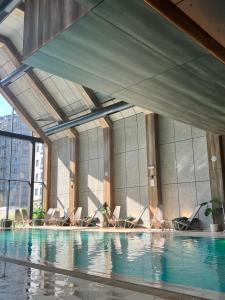 a swimming pool with lounge chairs in a building at Apartman Njegoš Lux Titova vila in Palisad