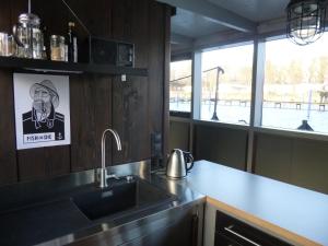 Hausboot Dänholm في شترالزوند: طاولة مطبخ مع حوض ونافذة
