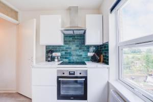 una cocina con estufa y ventana en Luxury 2 Bed in Reading - Free Parking & Fast Wi-Fi, en Reading 11 fotos más