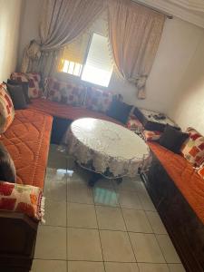 a living room with a table and a couch at Très belle Appart à louer pour vos vacances-Dyafa Agadir- A 2chambres in Agadir +33 photos