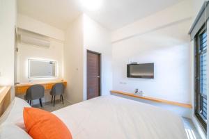 a bedroom with a bed and a tv on the wall at Aidao B&B in Dazhou