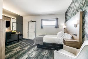 a hotel room with a bed and a desk at Manitoulin Motel in Little Current