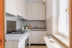 a kitchen with white cabinets and a stove top oven at Italian Experience- Loreto Suite Apartment in Loreto +30 photos