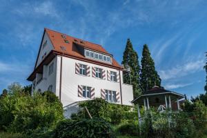un gran edificio blanco con techo rojo en Villa Schlössle, en Badenweiler