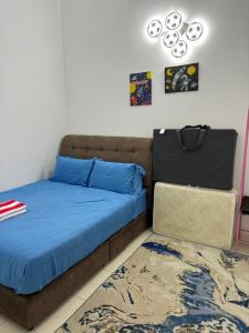 a bedroom with a bed with blue sheets and a rug at LaRinDa Teluk Kemang Private Pool - Islamic in Port Dickson +14 photos