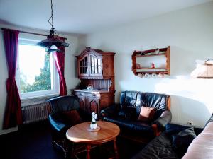 a living room with two leather chairs and a table at Ferienwohnung ENDORA im Harzer Stil, Handgefertigte Möbel - WLAN- GARAGE - Wandern-Mountainbike-Motorradurlaub in Hohegeiß