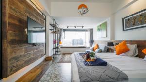 sala de estar con cama y pared grande en The Cabin Apartment Uttara, en Yogyakarta