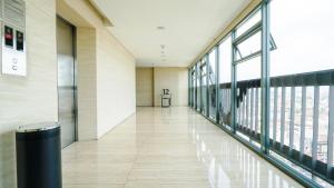 an empty hallway in a building with large windows at The Cabin Apartment Uttara in Yogyakarta