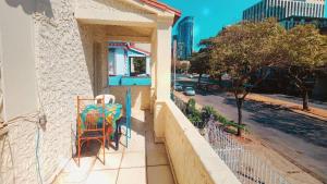a porch with a table and chairs on a balcony at Trem Chic in Belo Horizonte