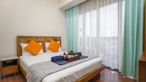 1 dormitorio con 1 cama con almohadas de color naranja y azul en The Cabin Apartment Uttara, en Yogyakarta