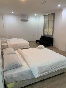 a room with three beds and a piano in it at GLhotel kudat in Kudat