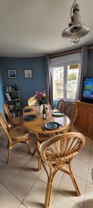 a dining room with a wooden table and chairs at Appartement La Plage Plouha in Plouha