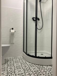 a bathroom with a shower and a tiled floor at Nowe studio blisko Atlas Areny in Łódź