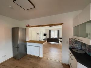 a kitchen with a refrigerator and a living room at 3 Schlafzimmer l Südbalkon l Waldrand l Saniert in Hagenburg