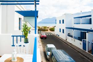 カレタ・デ・ファマラにあるAsana Surf House Famaraの路上に車が駐車されている家のバルコニーからの眺め