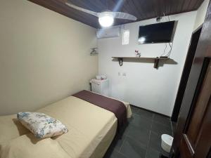 a small room with two beds and a flat screen tv at Recanto do Abraao in Abraão +13 photos