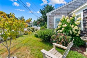 a white bench in front of a house with a tree at 227 Winter St, Hyannis in Barnstable