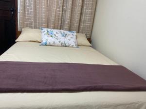 a bed with a purple blanket on top of it at Recanto do Abraao in Abraão