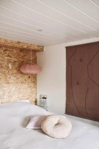 ein Bett mit einem rosa Kissen darüber in der Unterkunft Heerlijk huisje op de Veluwe in Putten in Putten