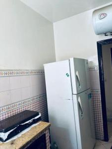 a kitchen with a white refrigerator in a room at chic chambre meublée in Casablanca