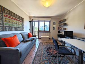 a living room with a blue couch and a desk at Hostdomus - Pastore Apartment in Sestriere