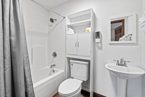 a white bathroom with a toilet and a sink at Utopian Bliss in Sevierville +37 photos