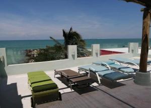 a group of lounge chairs and the beach at Courtyard family room in Chelem