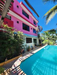a house with a swimming pool in front of a building at Courtyard family room in Chelem
